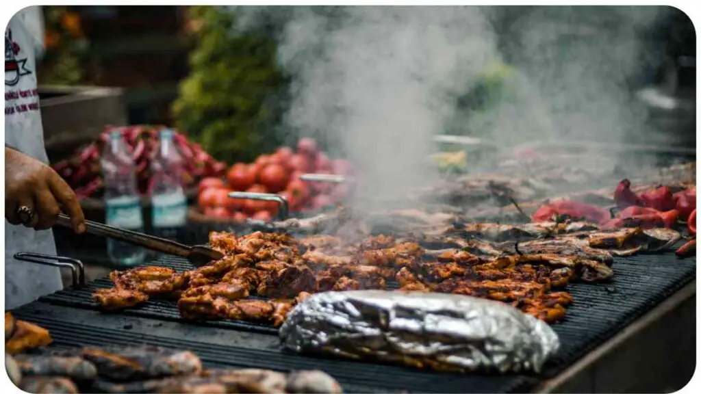 a person grilling meat on a grill with smoke coming out of it