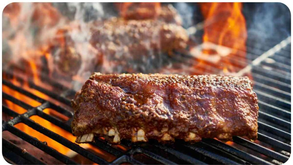 ribs on a grill with flames and smoke